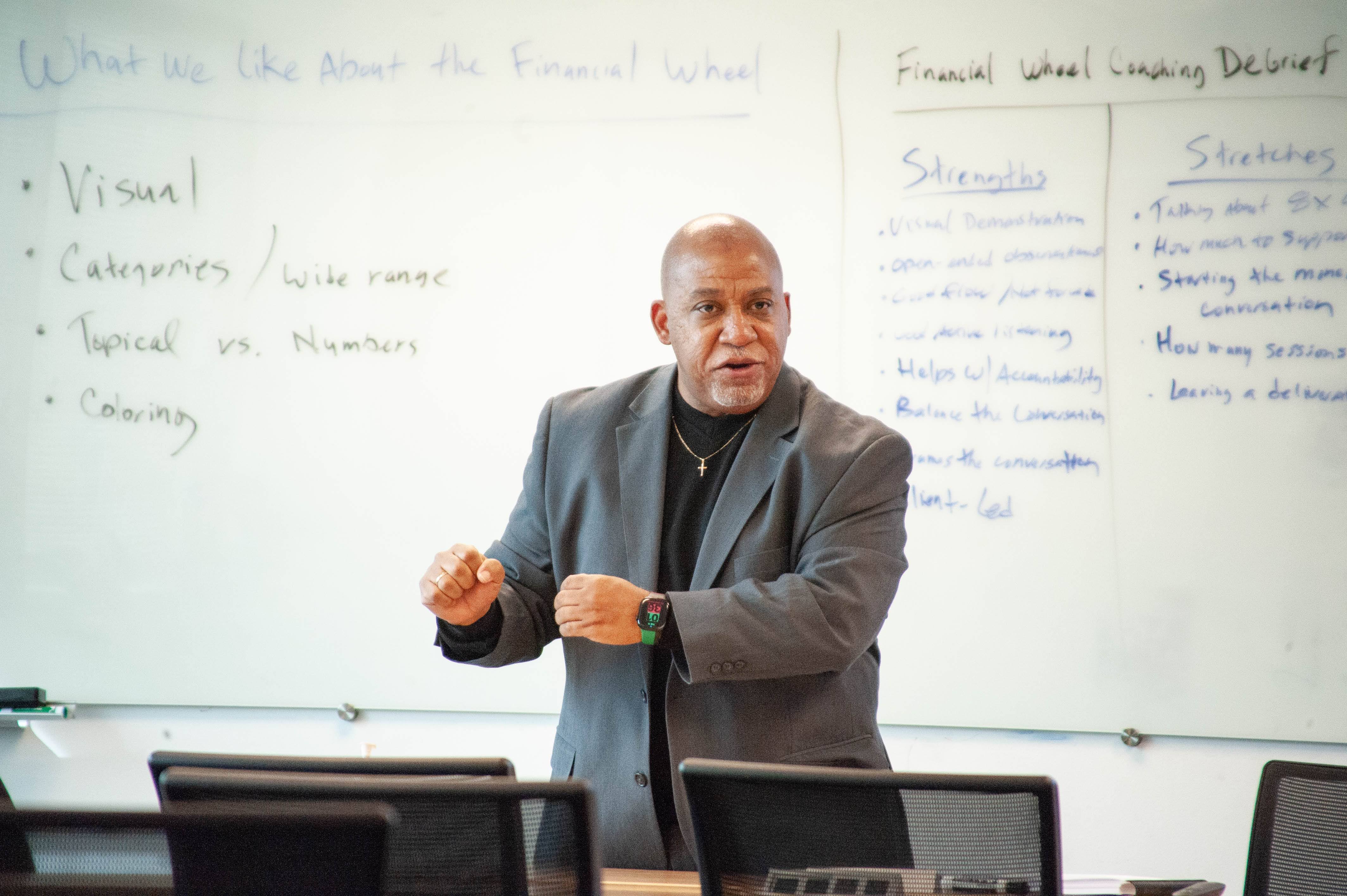 Devin Stubblefield teaching in front of a whiteboard during a professional coaching training