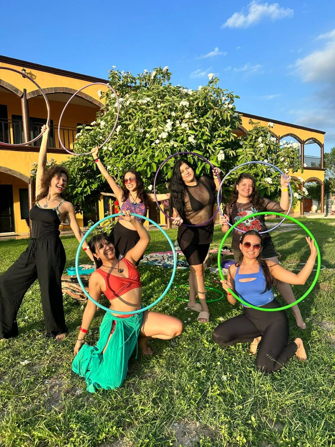 Diverse HoopYogini trainees practicing hula hoop yoga and mindful movement together.