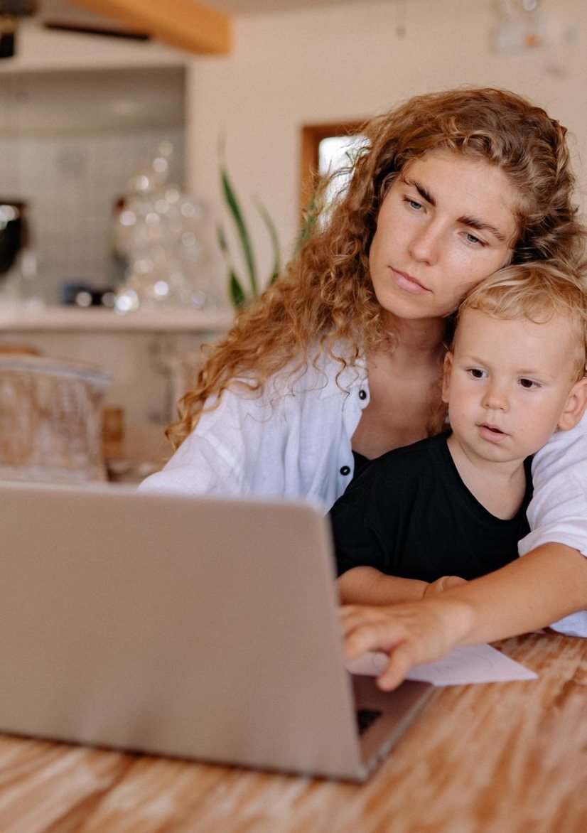 Mother working on a laptop at home with her baby on her lap