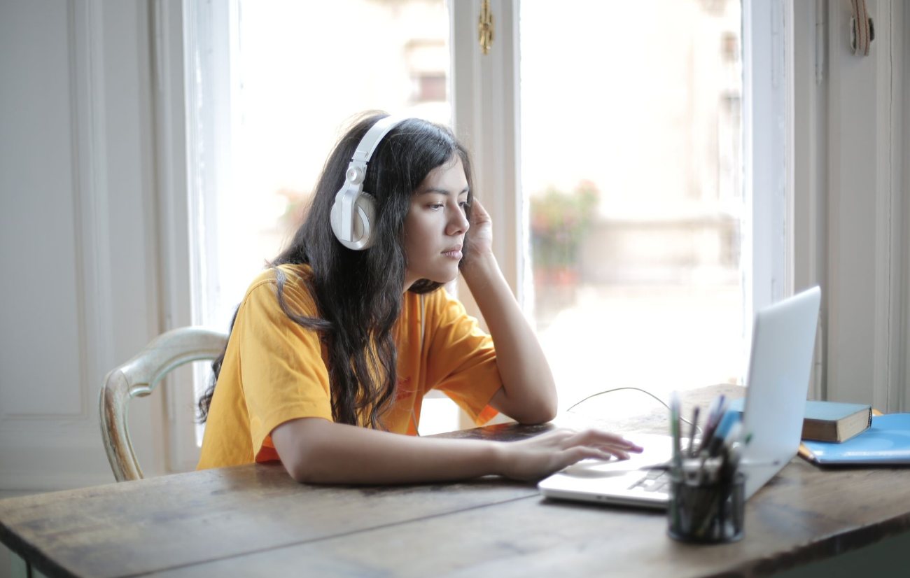 Transcriptionist working at a desk with headphones and a laptop