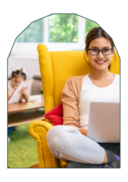 Parent at kitchen table working on a laptop