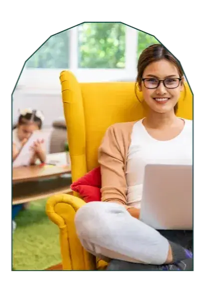 Parent at kitchen table working on a laptop