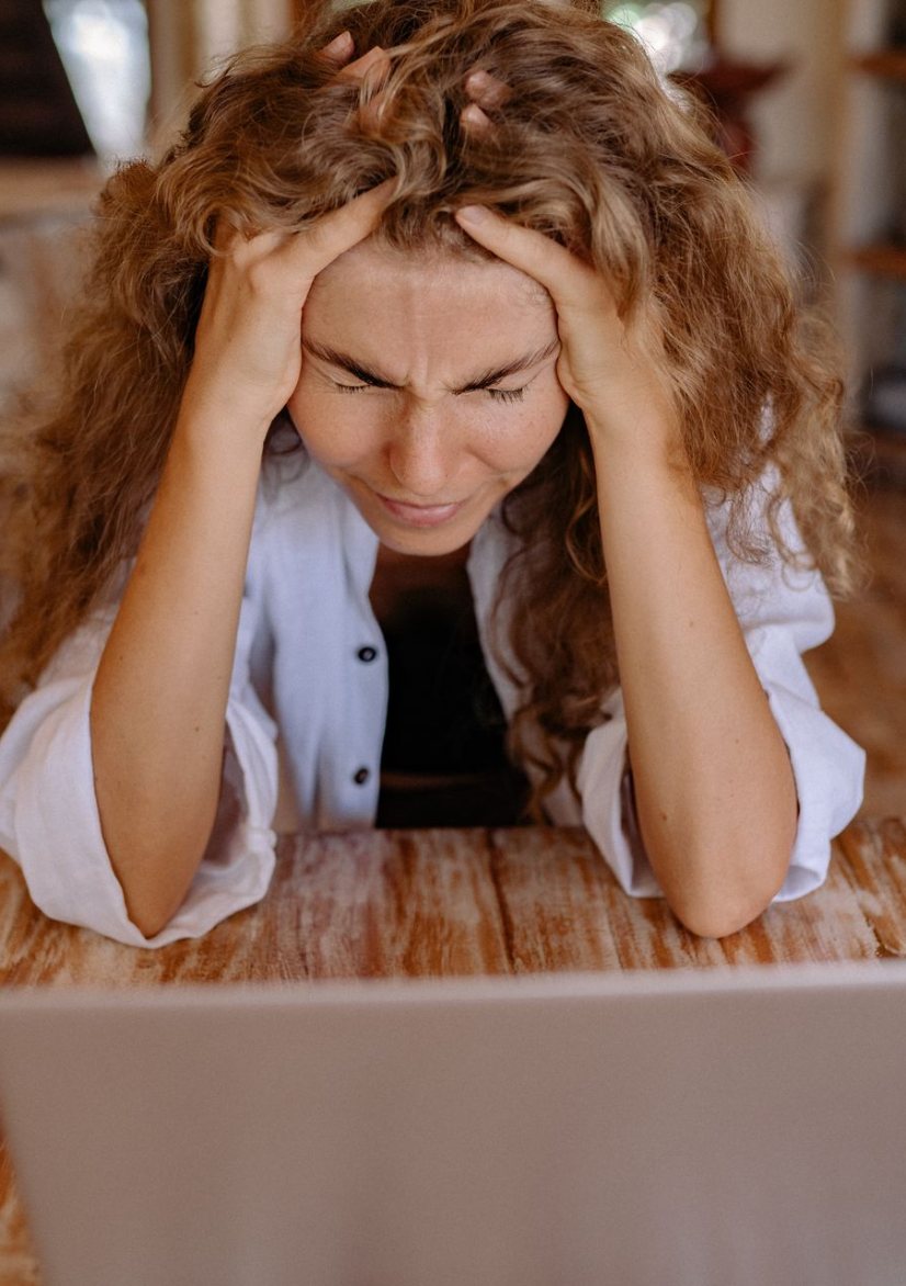 Worried woman at a laptop in a home workspace