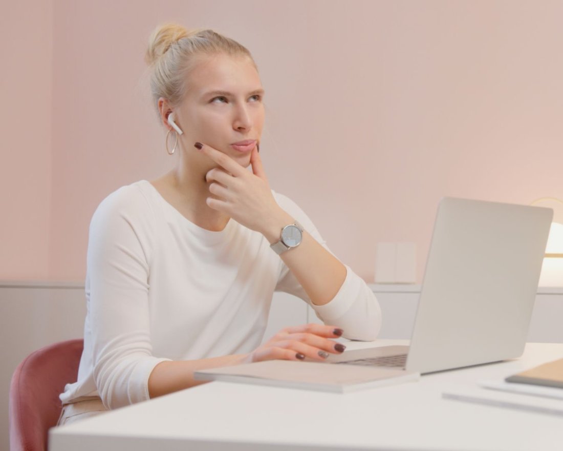 Woman thinking at her laptop in a home office