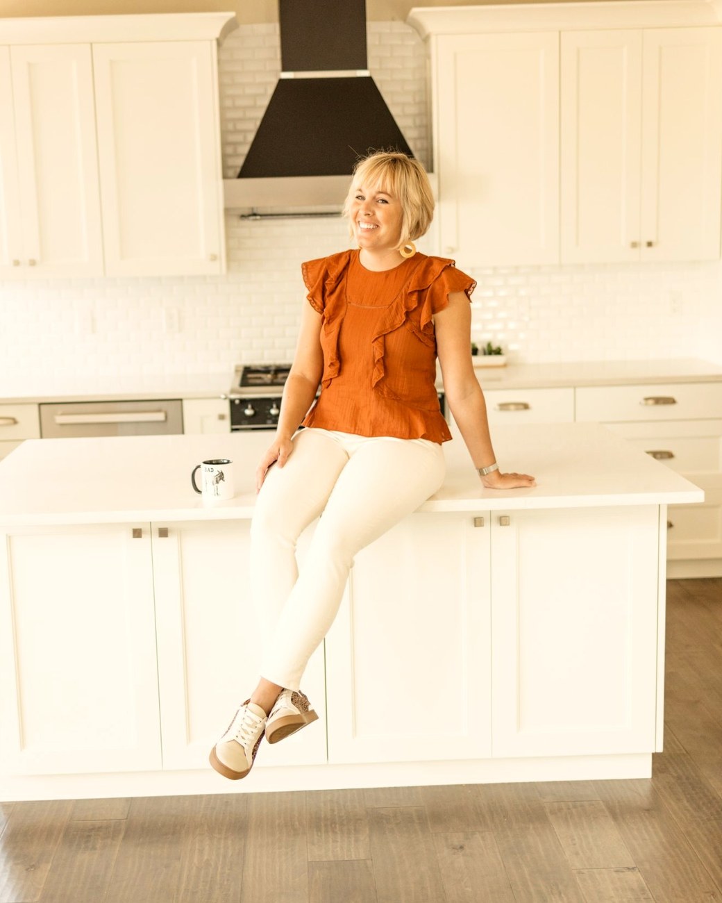 Sarah sitting on her kitchen island, laughing