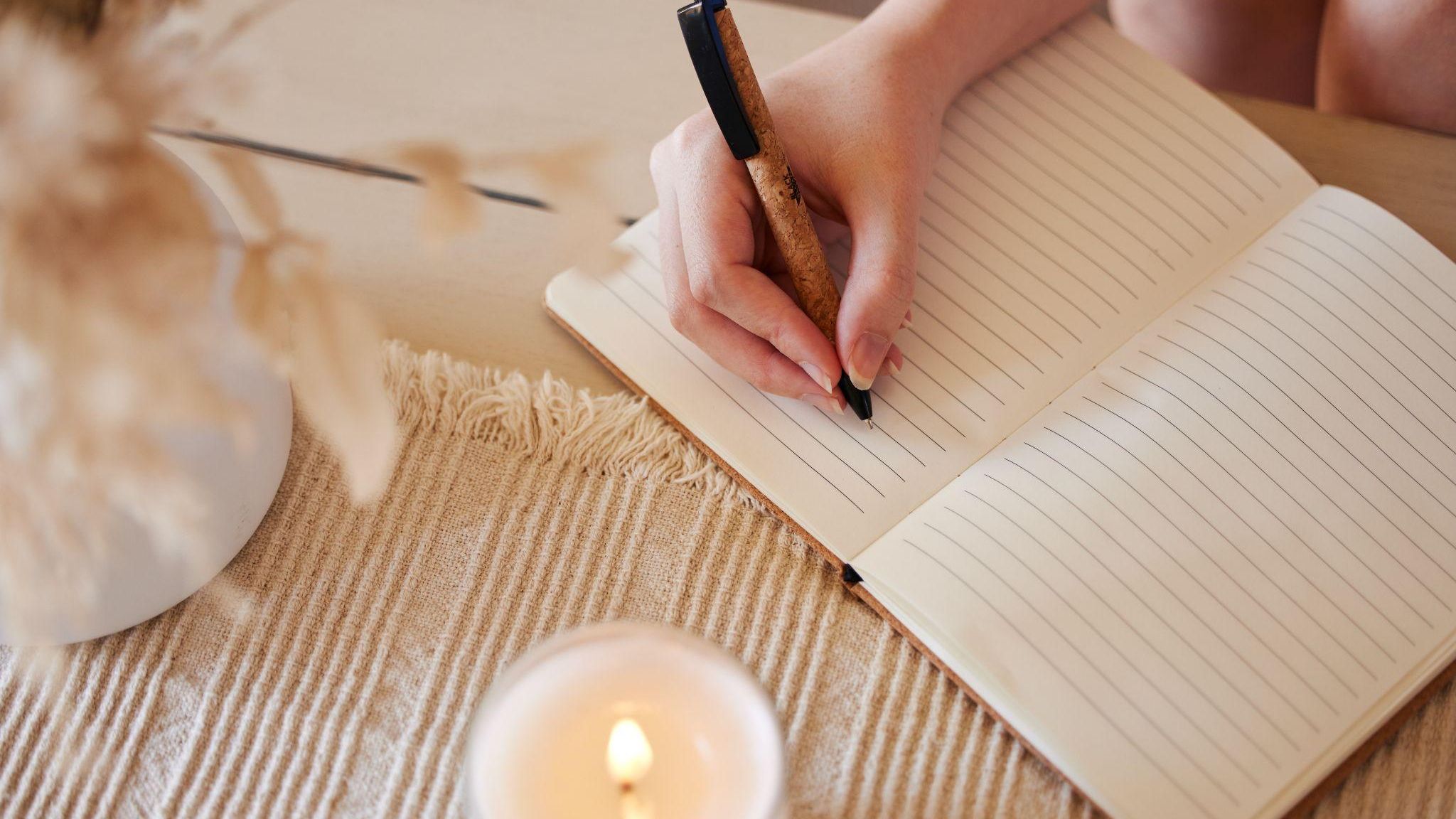 Woman writing in a sobriety journal, doing the reflective work of recovery with intention and focus