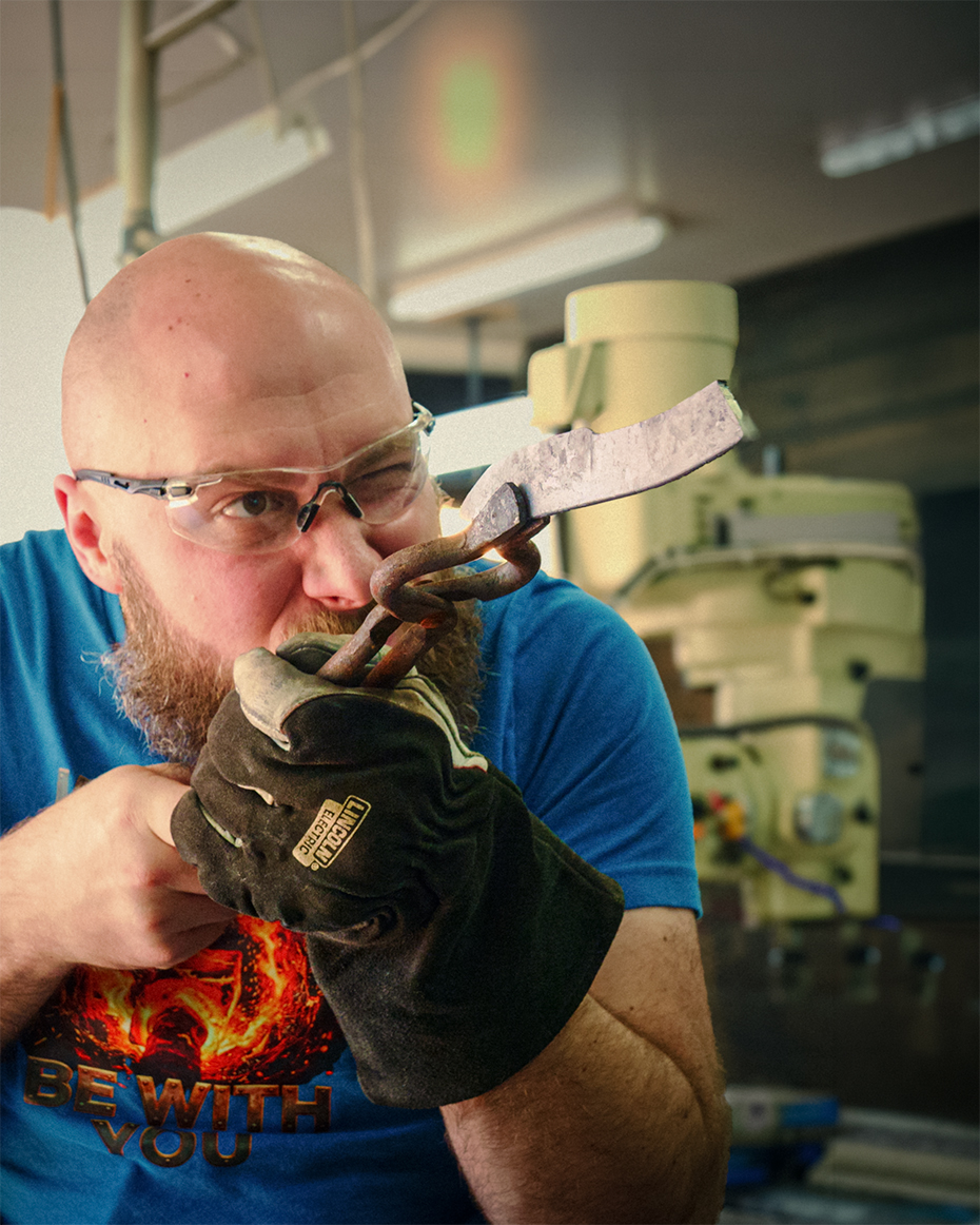 Kyle inspecting a forged blade in the shop