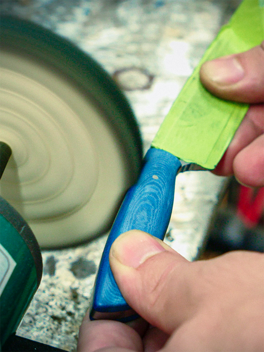 Blue handle being shaped at grinder