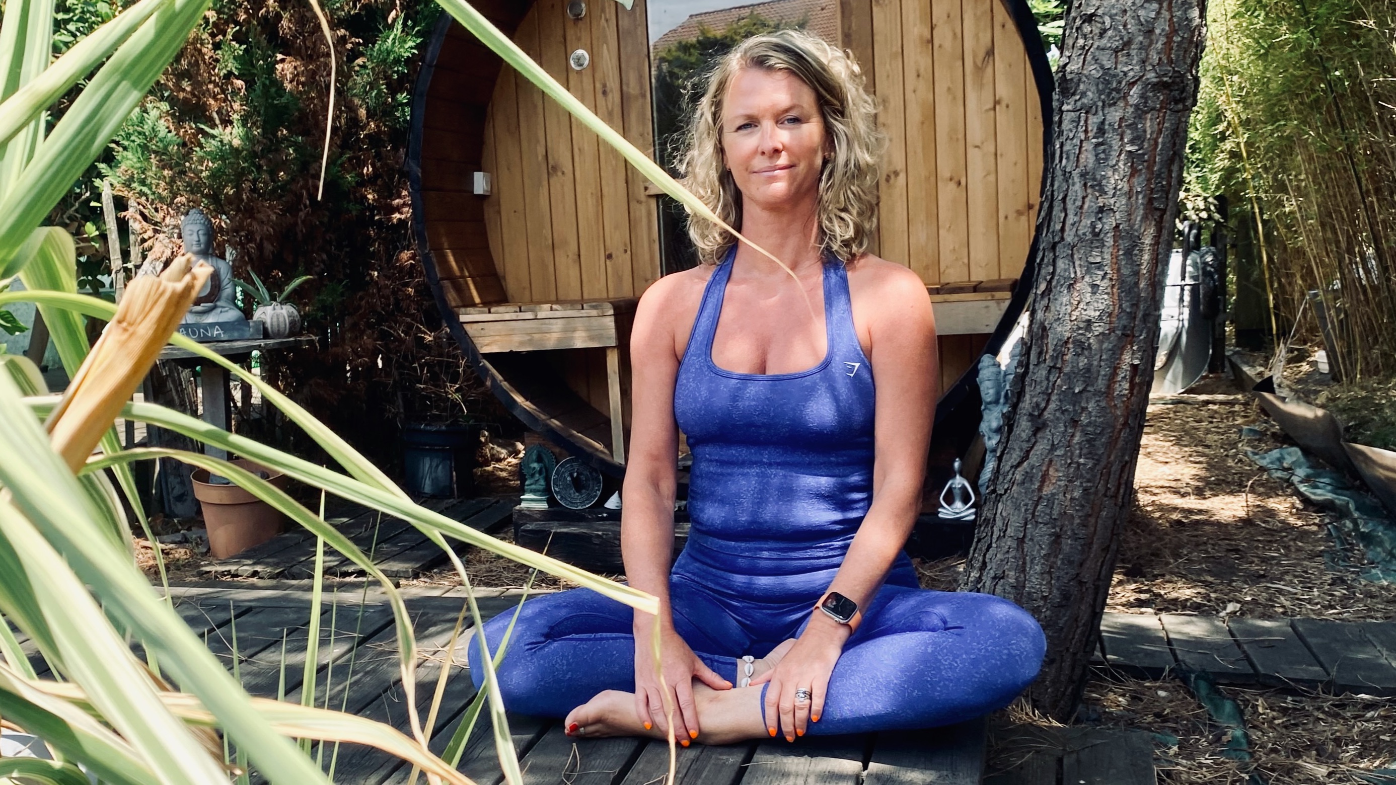 Professeure de yoga assise en méditation dans un espace naturel, illustrant une transmission du yoga humaine, authentique et vivante.