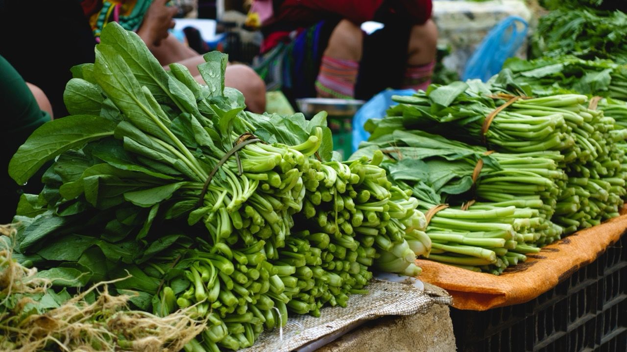 Green leafy vegetables like spinach at a farmer's market