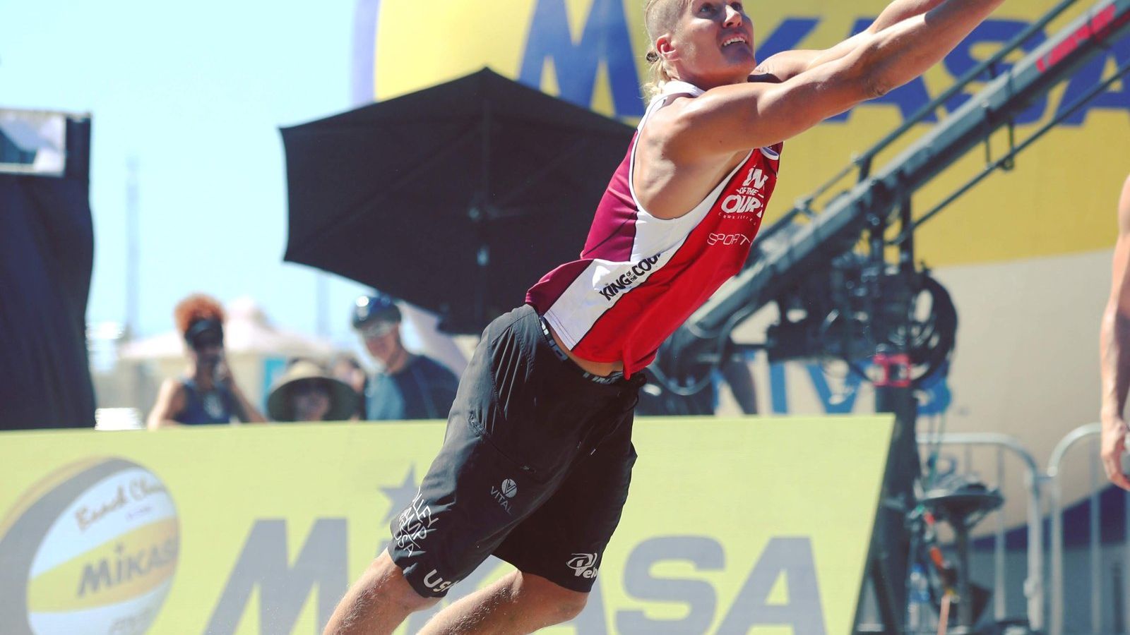 Mark Burik jump serving at a beach volleyball tournament