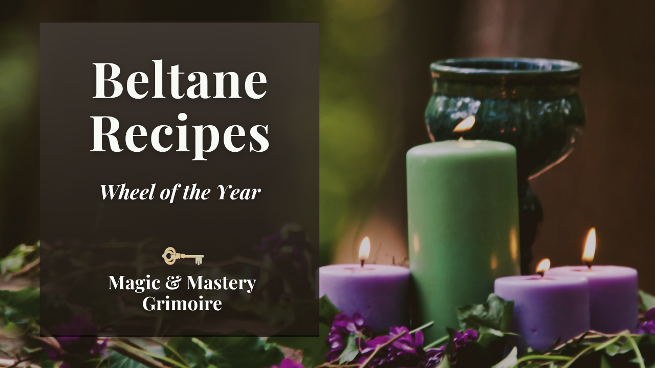 Pillar candles and purple flowers arranged on a bed of ivy leaves for Beltane