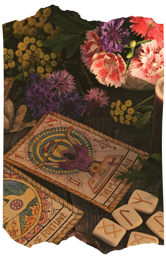 Tarot cards, rune stones, and flowers arranged for a divination reading