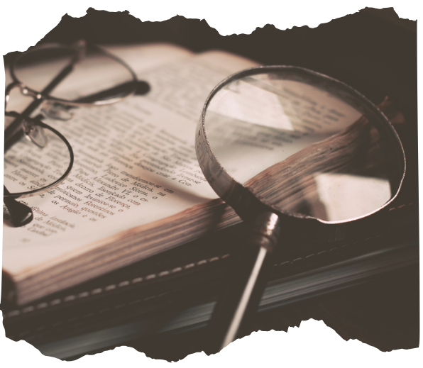 Magnifying glass and reading glasses resting on an open book