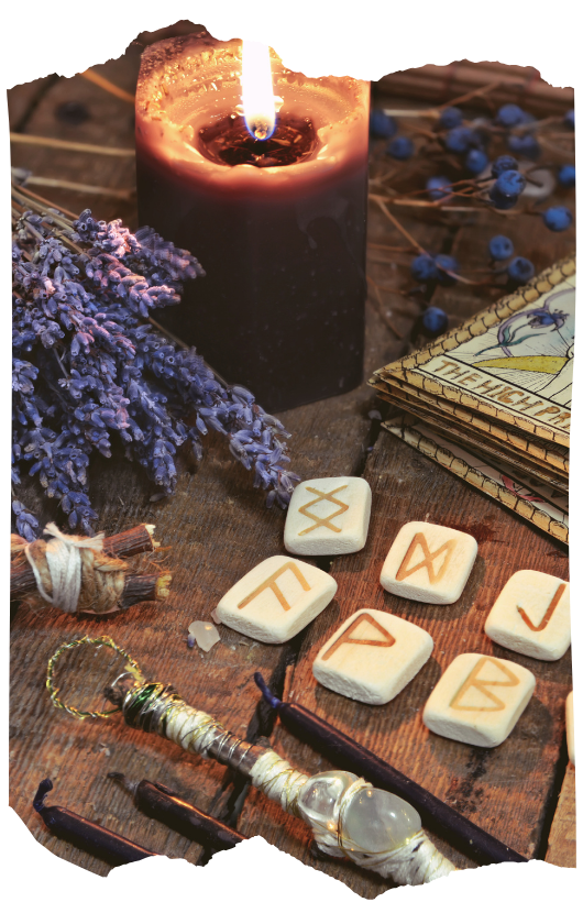 Rune stones, a lit candle, and dried lavender arranged for a divination ritual
