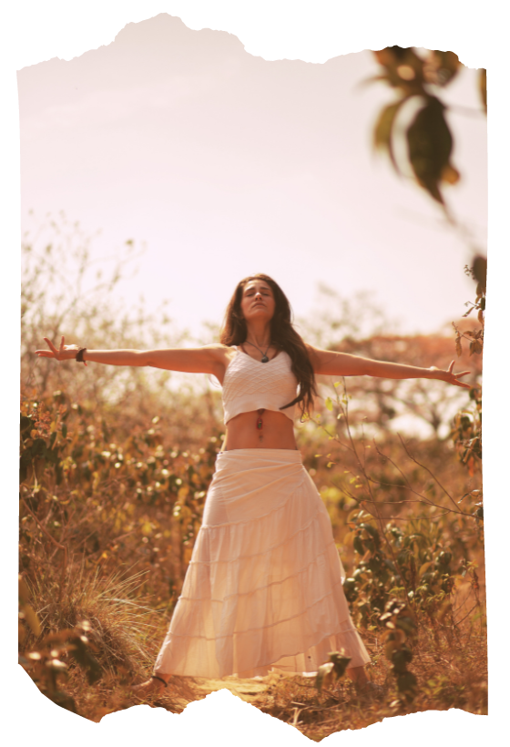 Woman standing in a sun-drenched field with arms outstretched — ritual self-initiation and magical empowerment in Way of the Mage