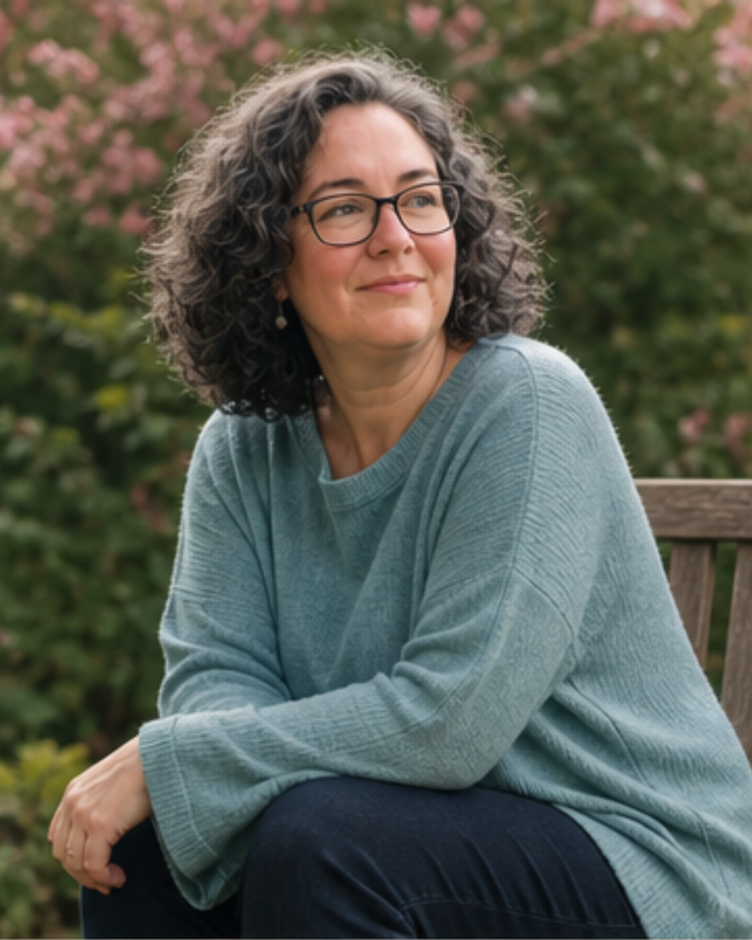 Jo-Anne Mac Millan, transpersonal therapist and mentor, seated outdoors in a garden setting