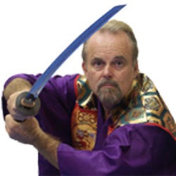 Richard Van Donk holding a sword in formal martial arts training attire.