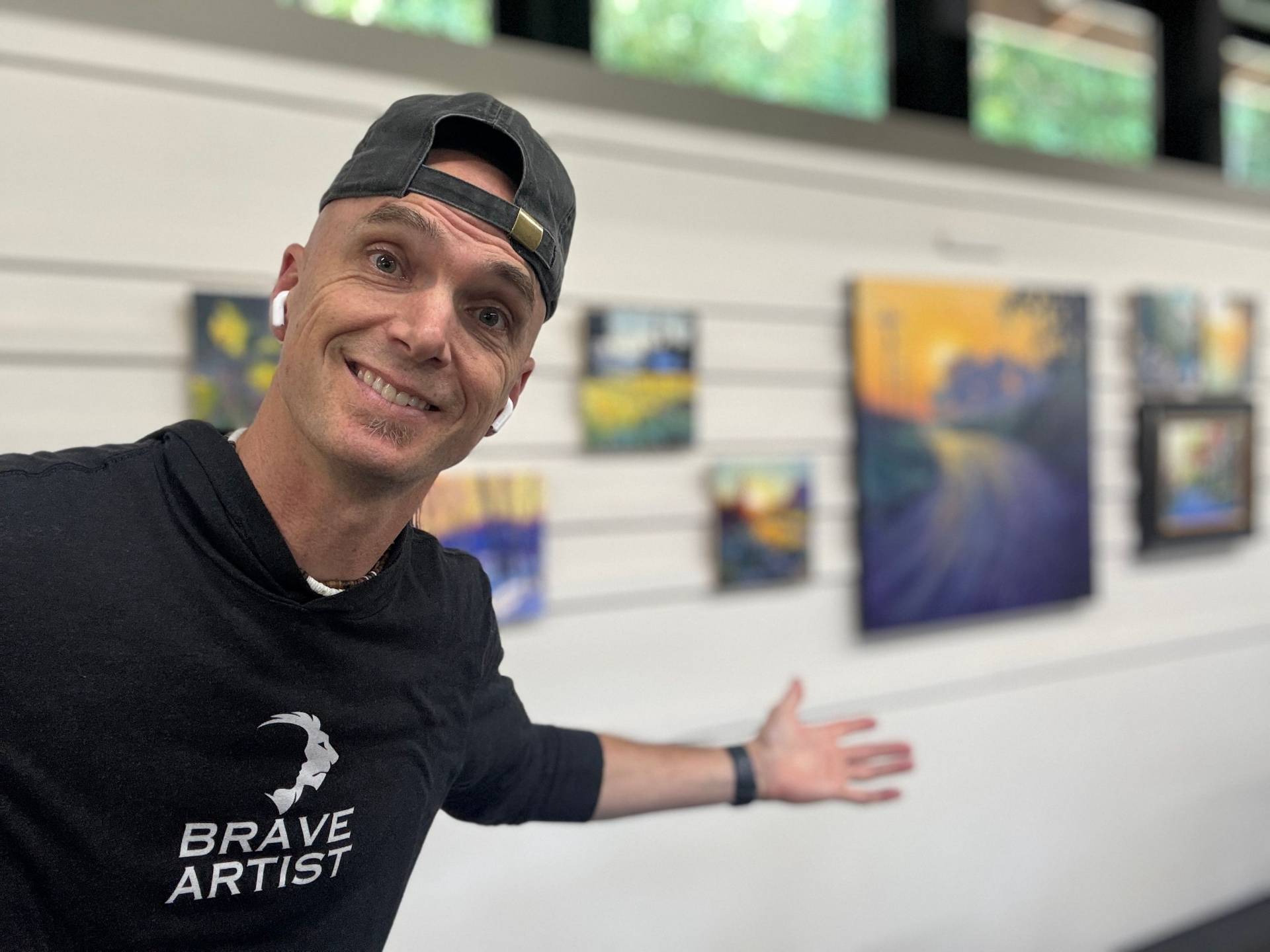 Jed Dorsey with a wall of his original paintings