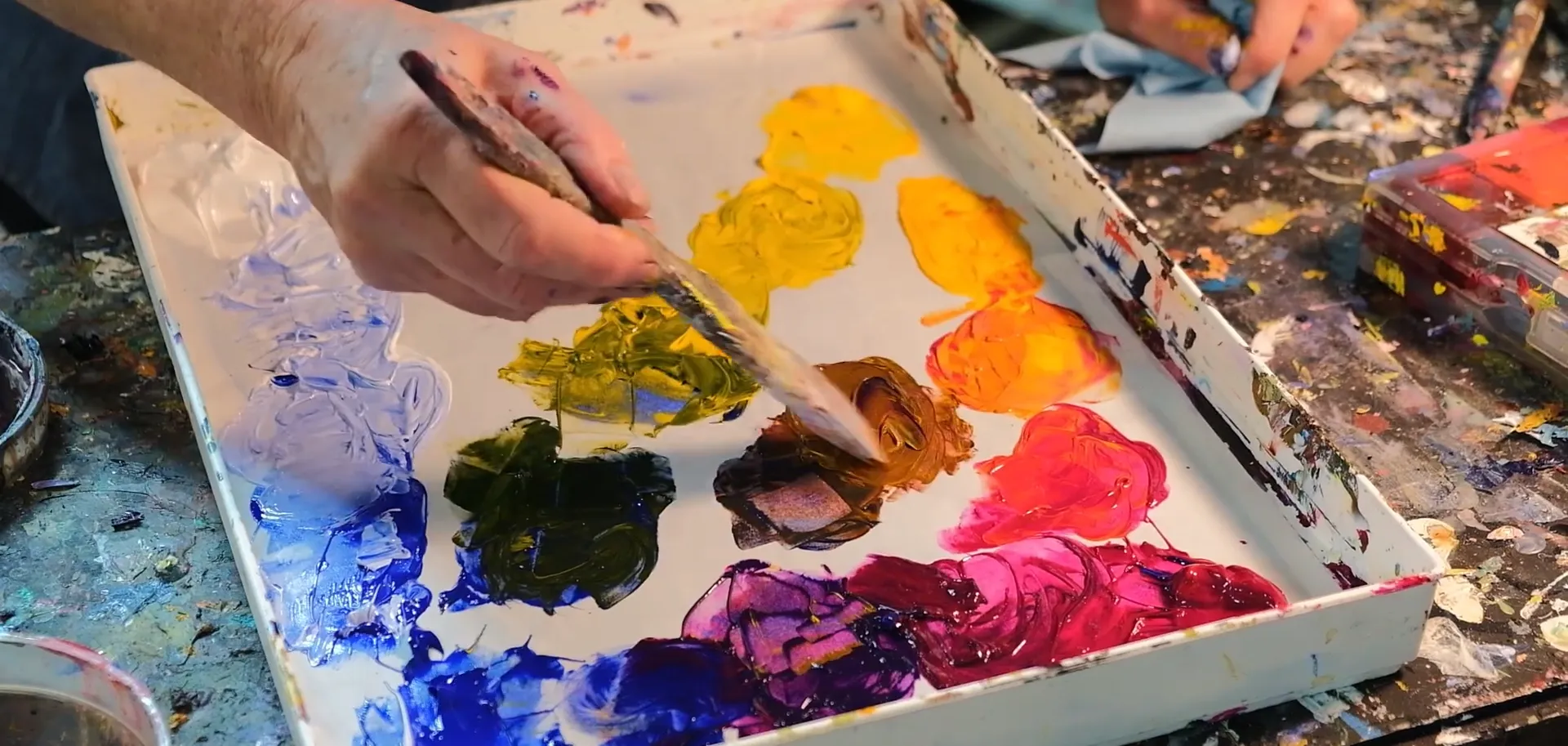Acrylic paints being mixed on a stay-wet palette organized by color