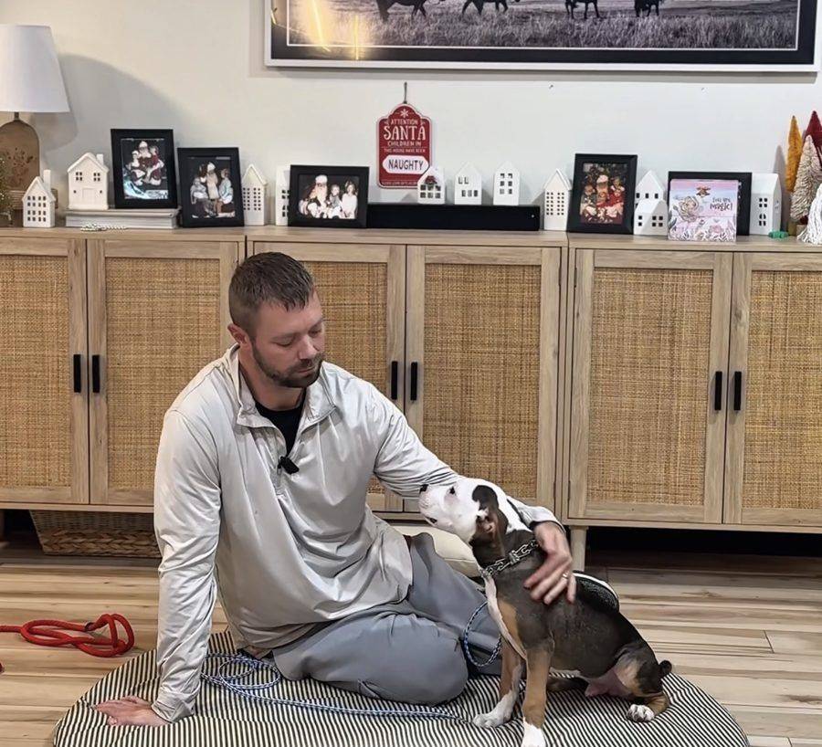 Lee bent down petting a dog