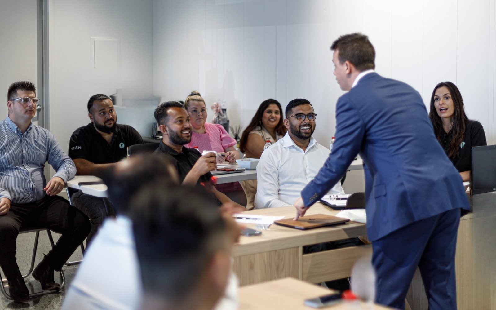 Aaron Shiner with a sales team in their office, everyone laughing