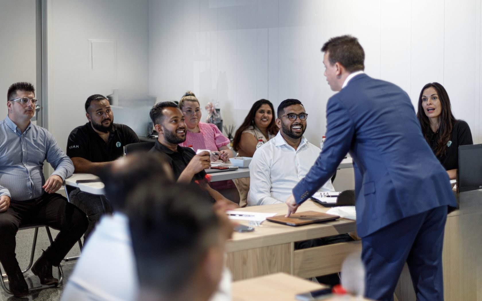 Aaron Shiner working the room during an in-office coaching session, the team laughing
