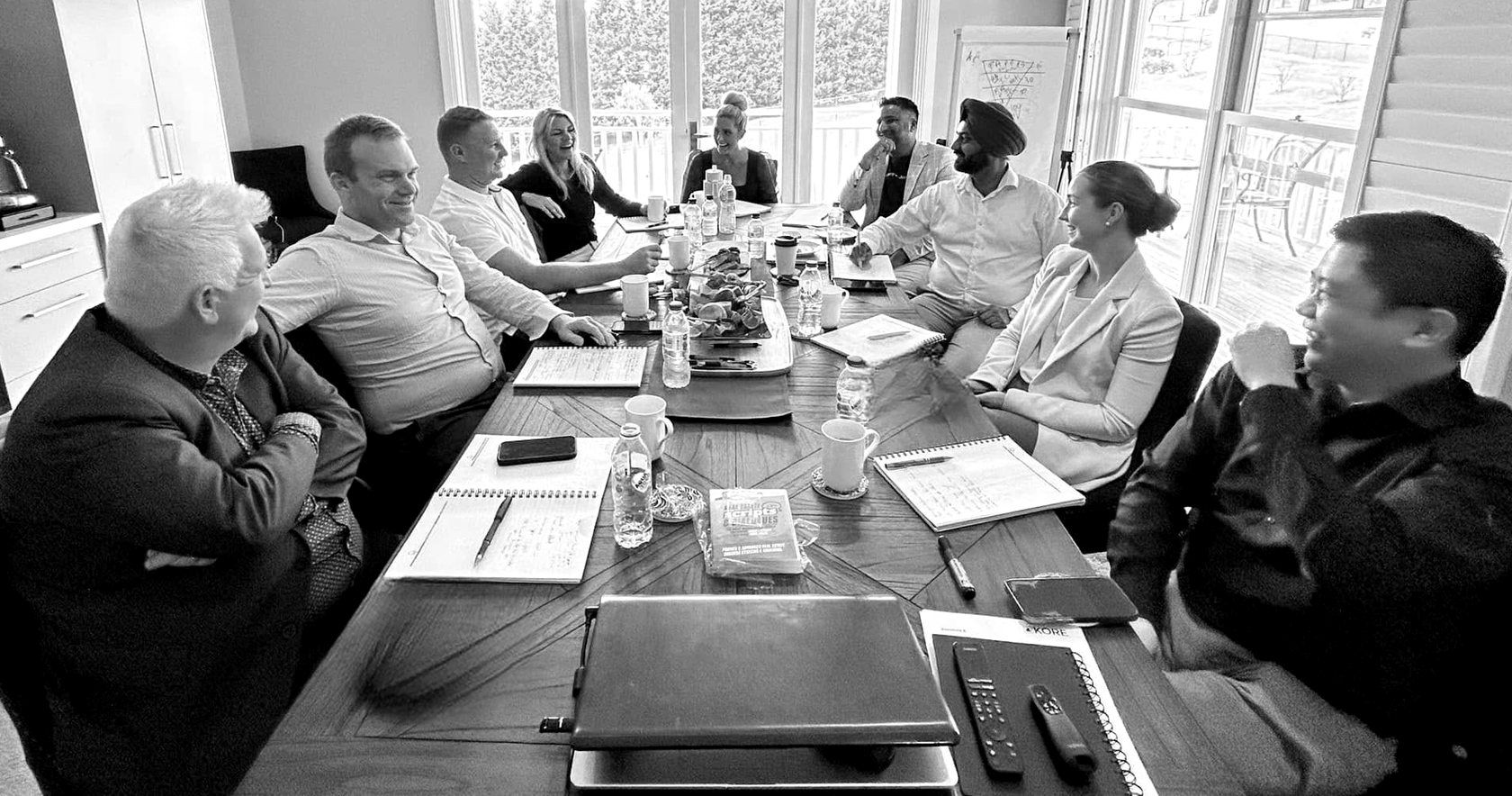 Nine agents around the table at the Retreat, mid-conversation