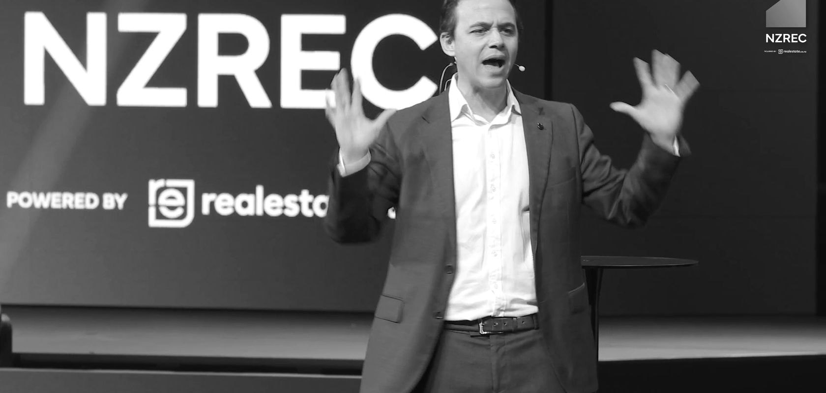 Aaron Shiner on stage at NZREC, mid-keynote