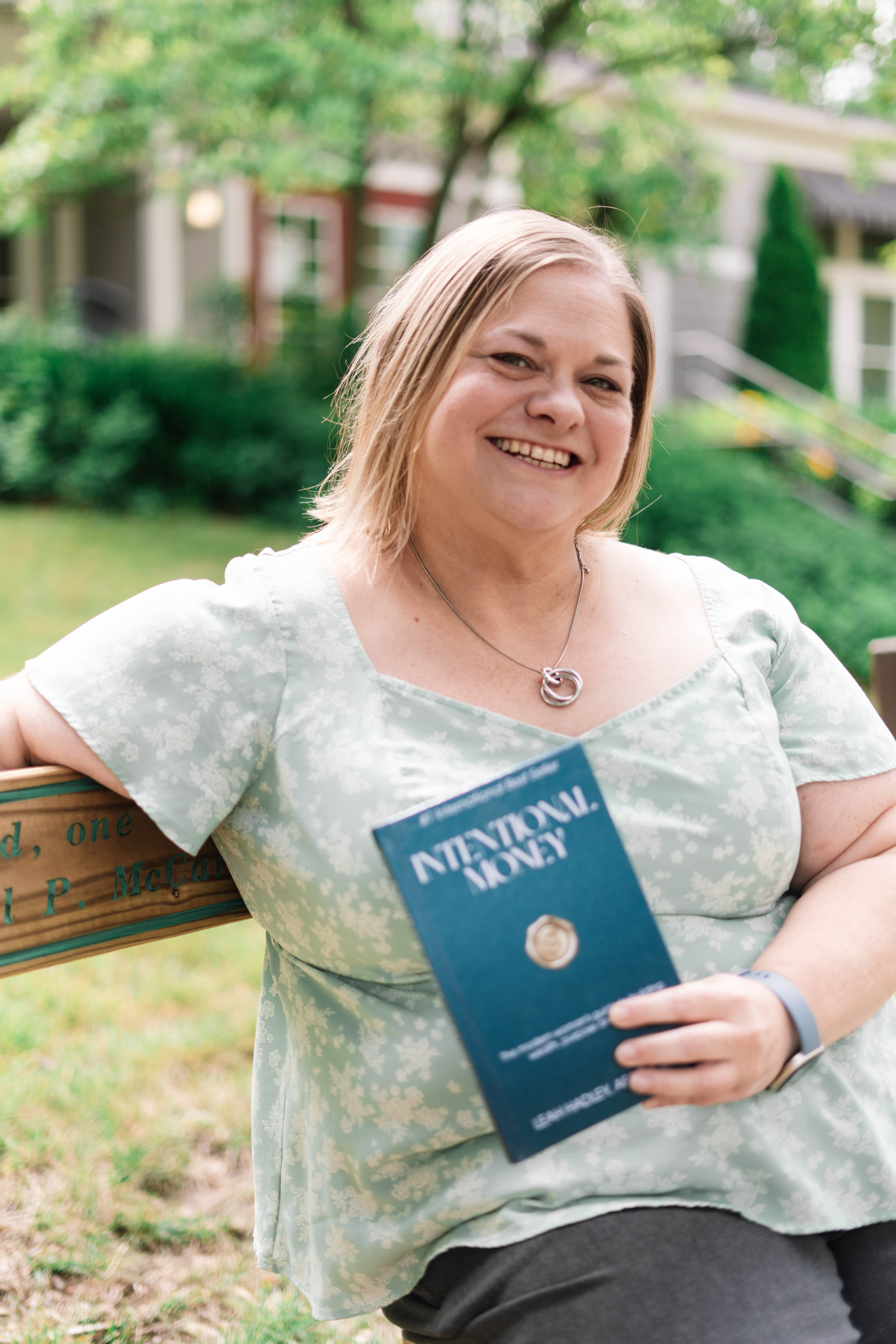 Leah Hadley holding her book Intentional Money
