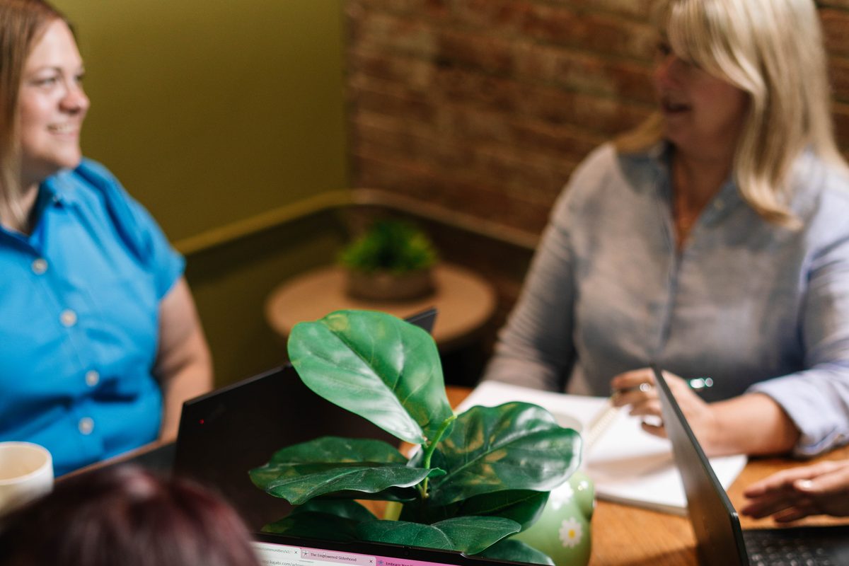 Women reviewing their business together at laptops
