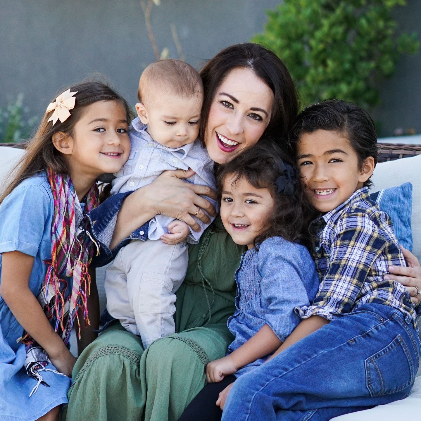 Maria smiling on the couch with her kids at home