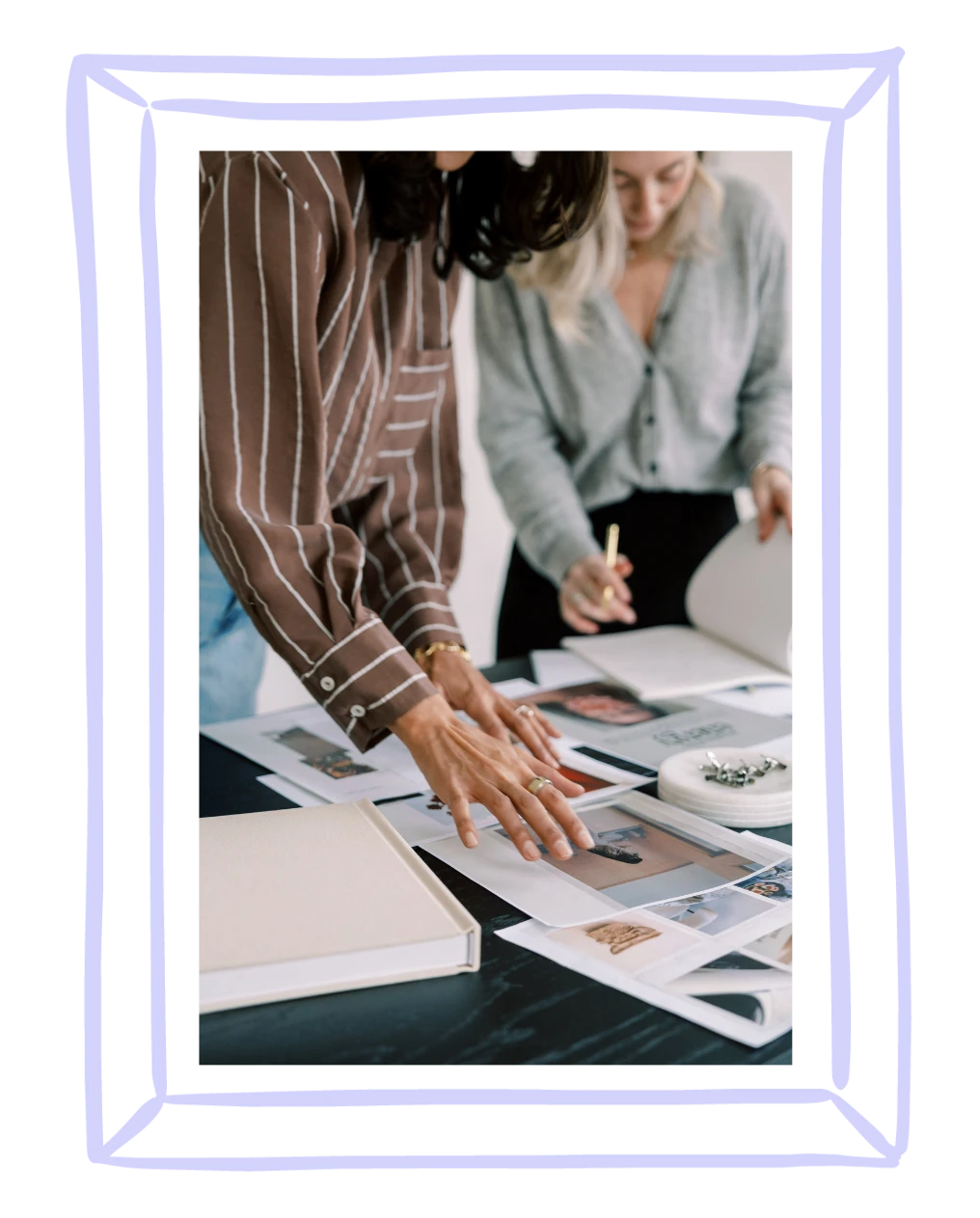 Two women working together, in a lilac frame