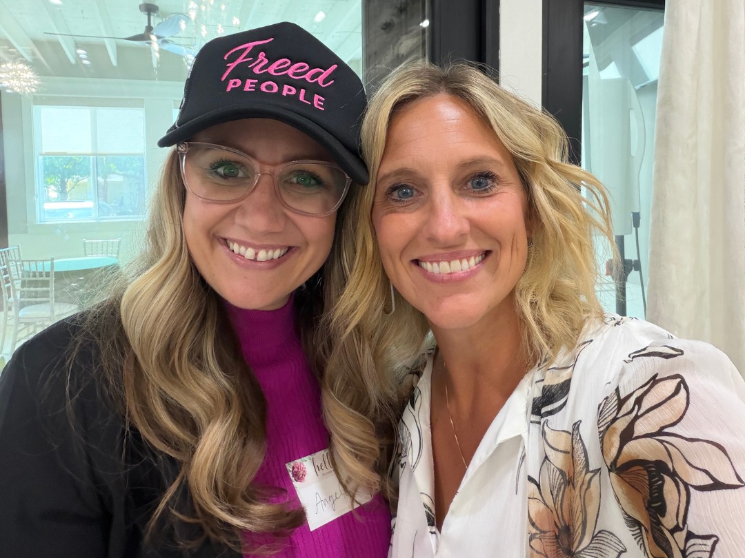 Two women entrepreneurs smiling together at an event