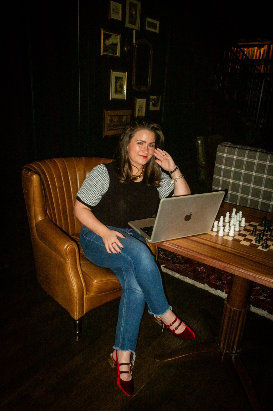 Jordan seated in a leather chair with a laptop