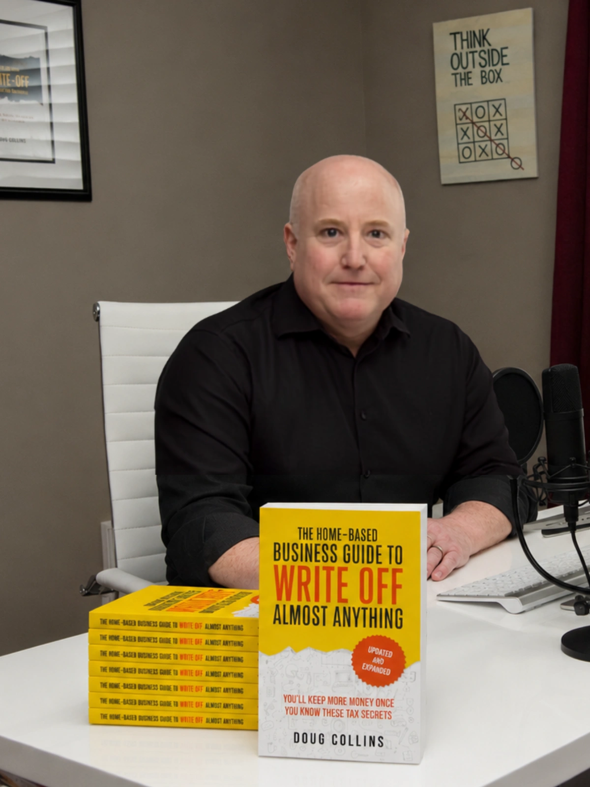 Doug Collins in his home office with The Home-Based Business Guide to Write Off Almost Anything