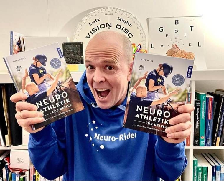 Marc Nölke hält sein Buch Neuroathletik für Reiter (KOSMOS)