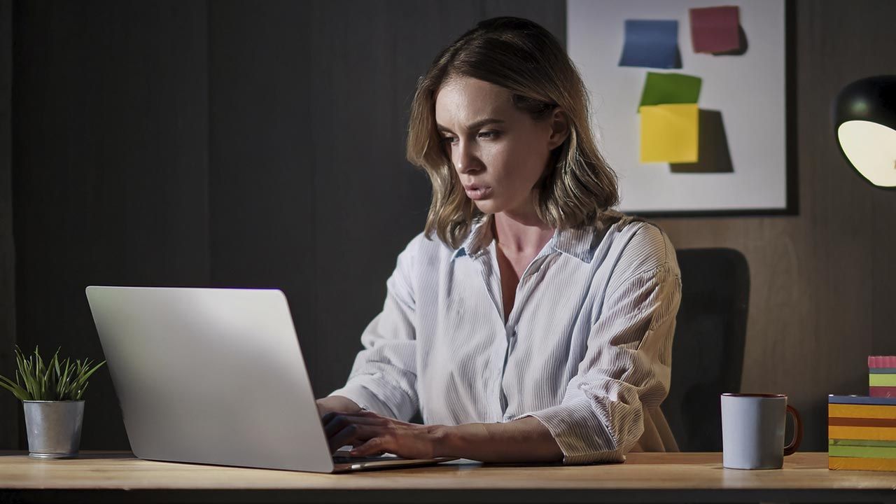 **Alt text:**  `A woman working late at her desk stares intently at her laptop screen in a dimly lit home office, surrounded by sticky notes and a coffee mug — the moment before a launch goes wrong.`