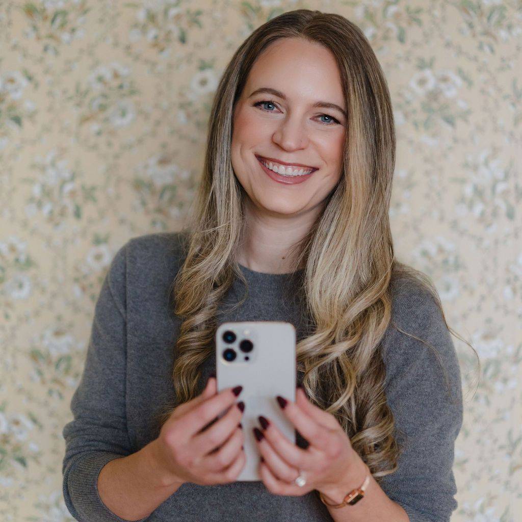 Laura Schoenfeld on her phone smiling