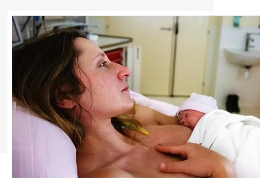Mother breastfeeding her baby while experiencing discomfort