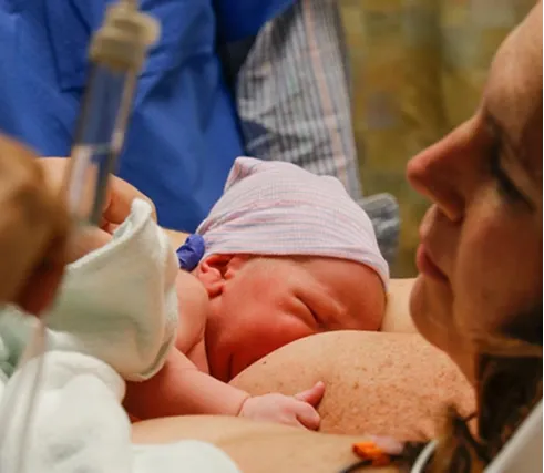 Woman breastfeeding newborn baby in hospital