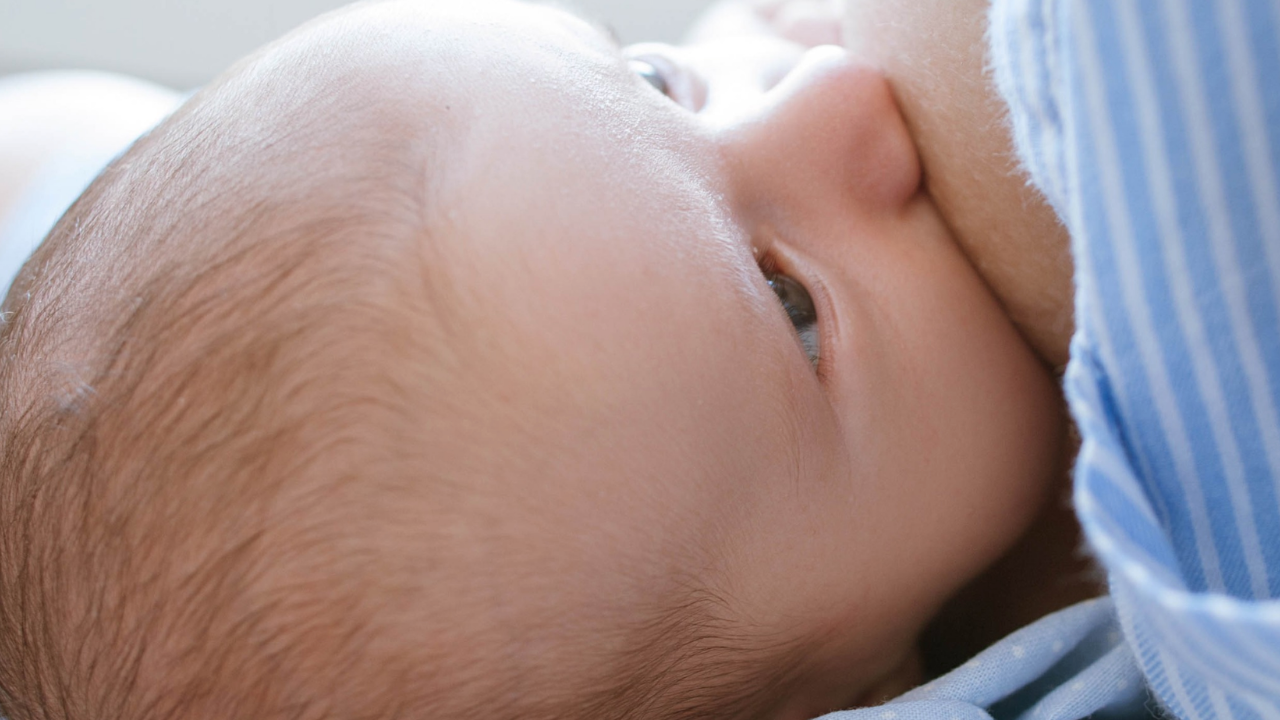 Women Breastfeeding Baby On Bed