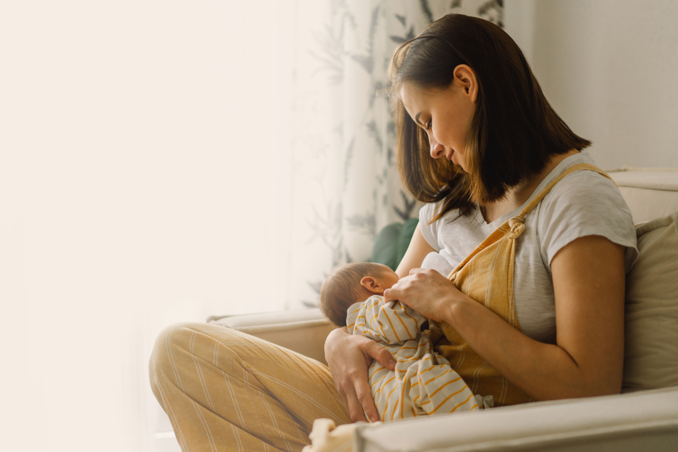 African American Women Breastfeeding In A Chair
