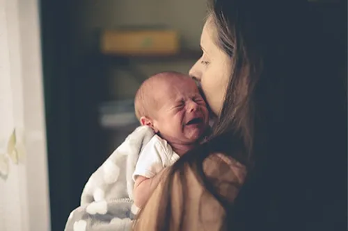 Newborn crying on mothers shoulders