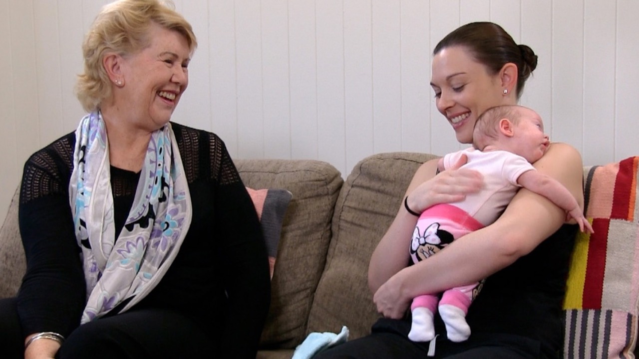 Dr Robyn Thompson alongside a breastfeeding mother and her baby