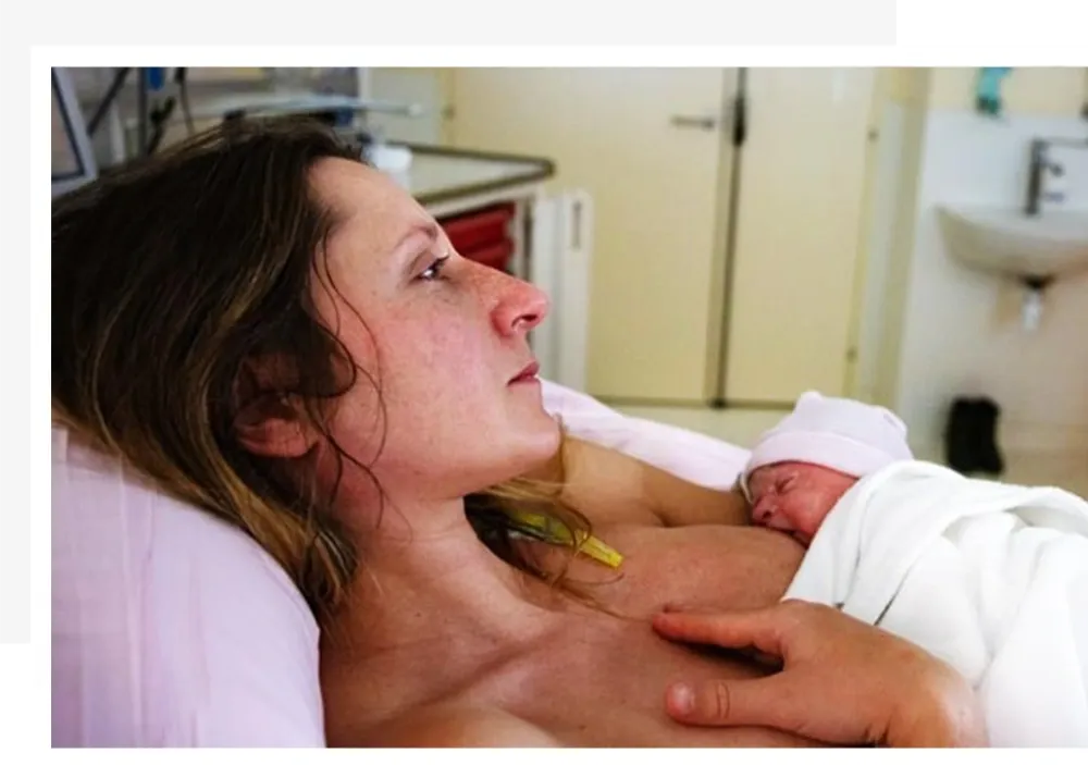 Mother breastfeeding her baby while experiencing discomfort