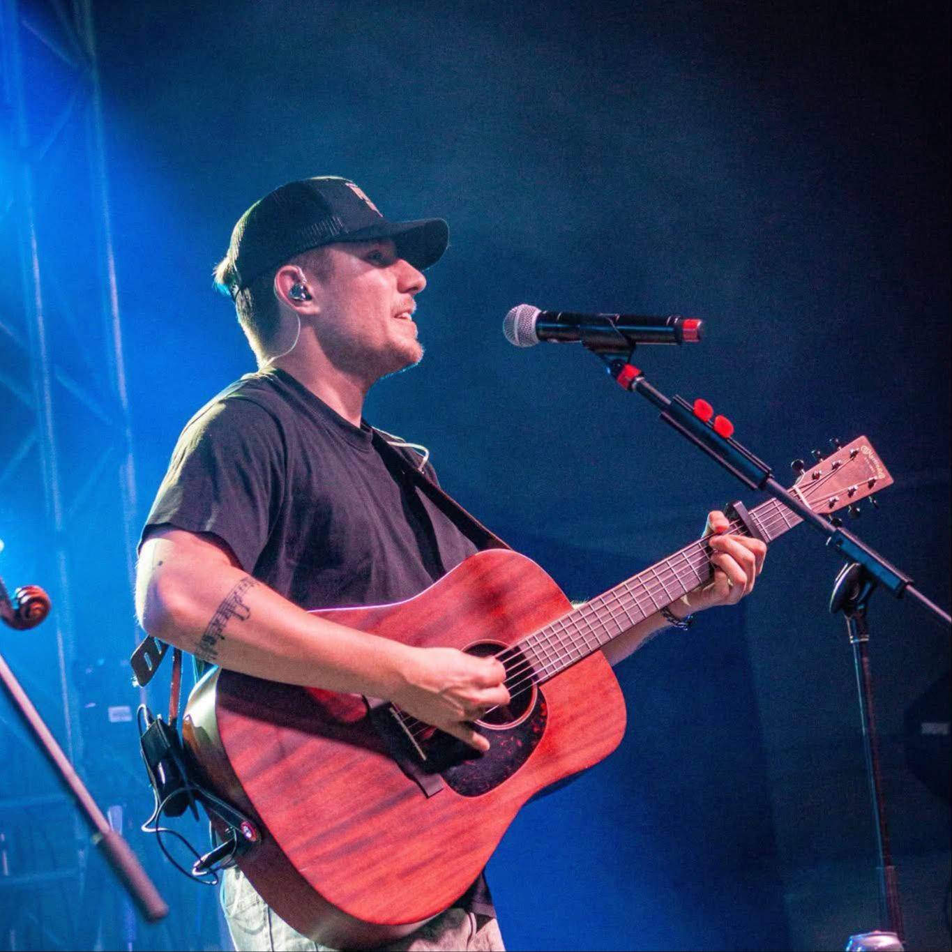 Philippe chante en s'accompagnant à la guitare sur scène