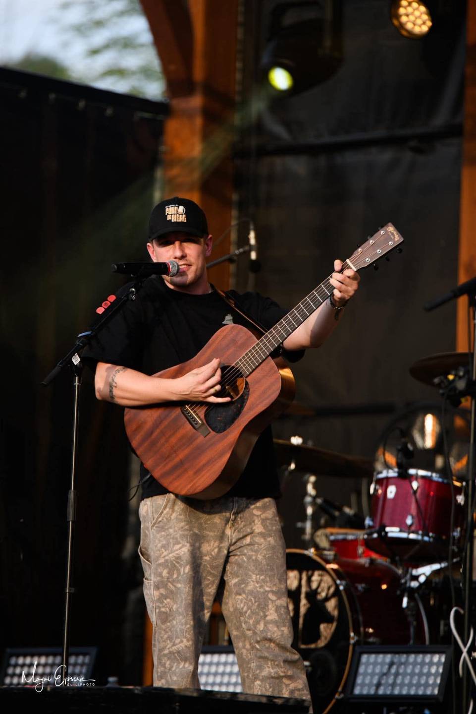 Philippe chante en jouant de la guitare sur scène