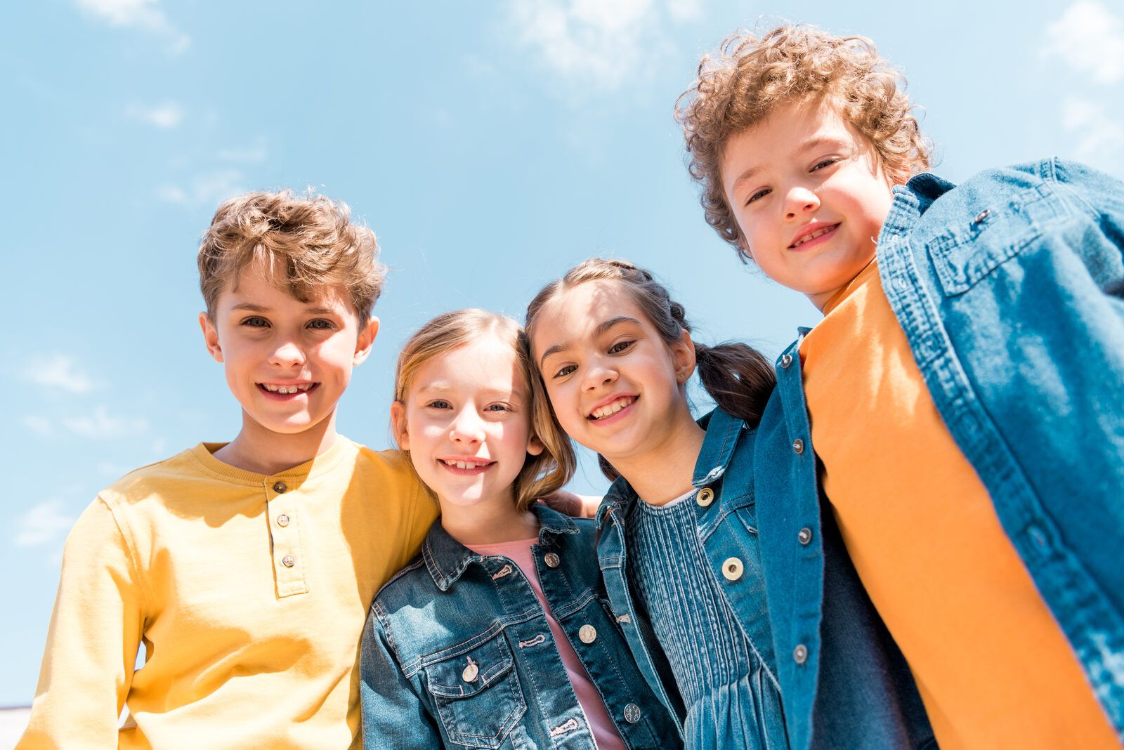 Four children smiling together outdoors