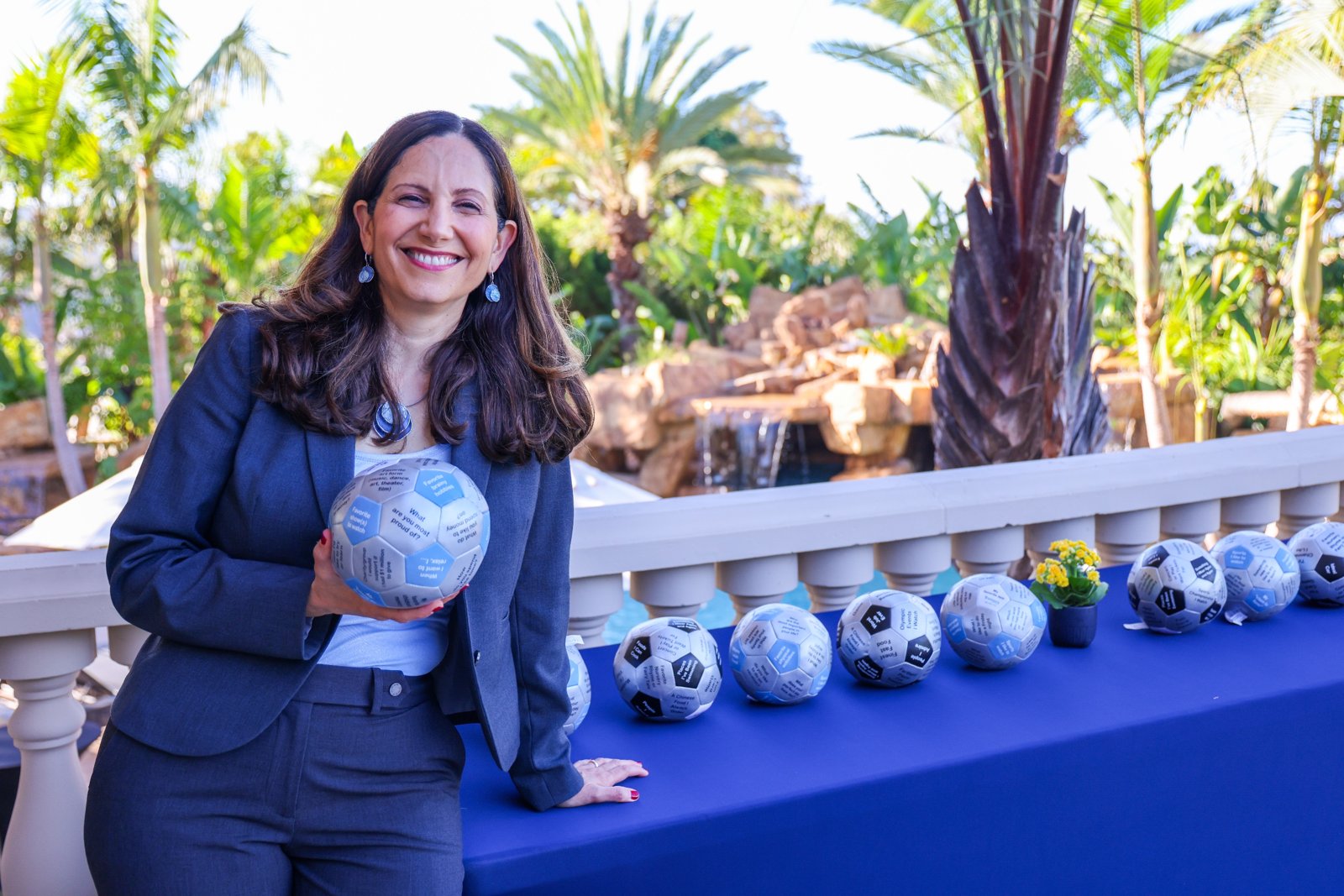 Vered smiling and holding a conversation ball at an outdoor leadership retreat
